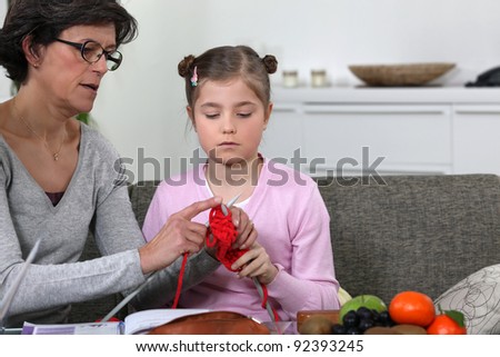 Grandmother teaching her granddaughter how to knit