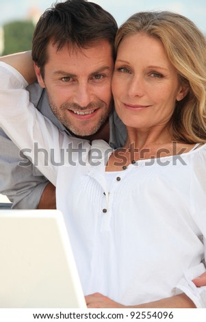 Couple with laptop in garden