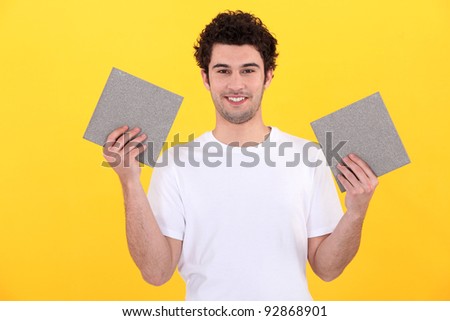 Man holding up tiles