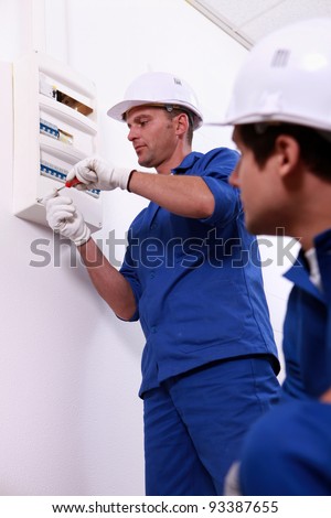 Tradesman repairing a distribution board