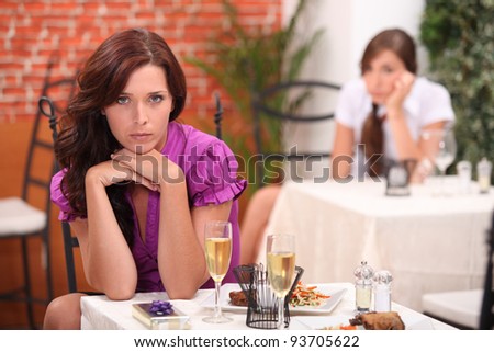 angry woman at the restaurant, on the table,  an unopened gift and flutes of sparkling wine