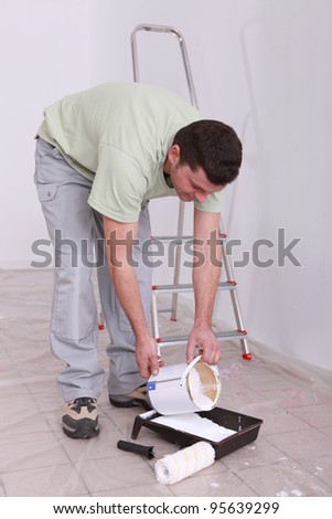 Decorator pouring paint into a tray