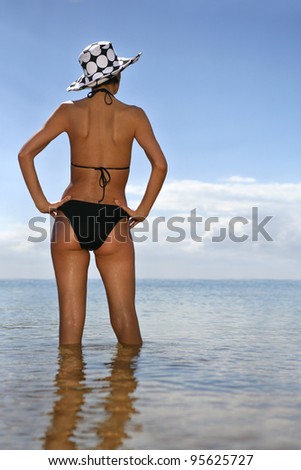 Brunette at the beach with her back to the camera
