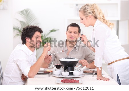 Three people enjoying fondue