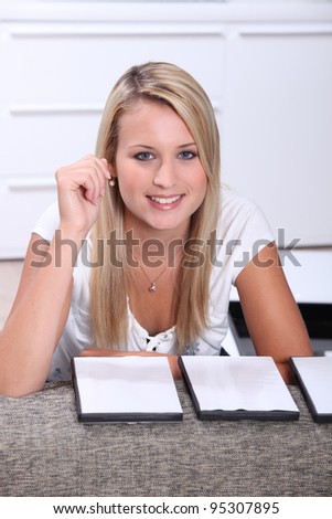 Attractive blond teenager choosing DVD at home