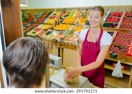 Shop assistant weighing fruit