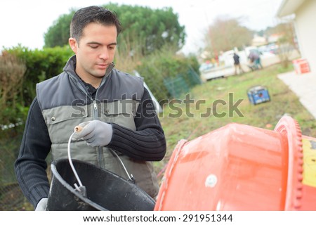 Pouring sand in to a cement mixer