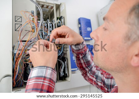 Electrician repairing a fusebox