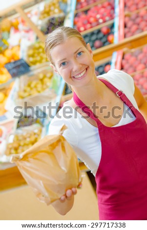 Supermarket worker holding a paper bag