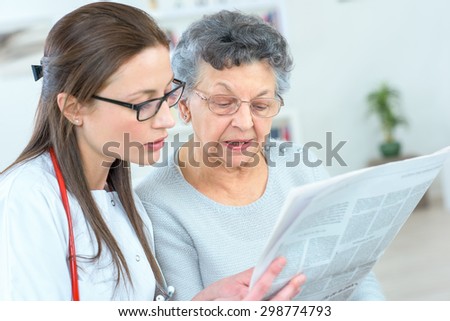 Reading newspaper with an old lady
