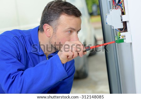 Electrician working on a fusebox