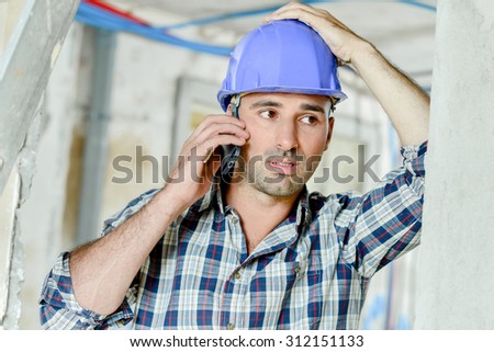 Builder on telephone, stressed