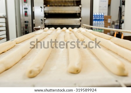 Prepared baguettes in front of a bread oven
