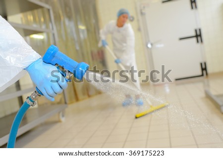Factory worker cleaning floor