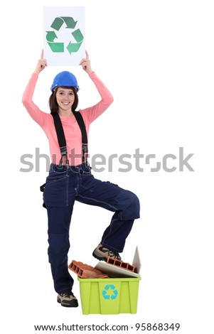 female bricklayer holding recycling logo against white background