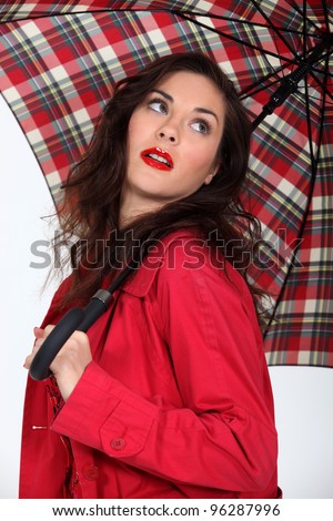 Woman in a red coat with a tartan umbrella