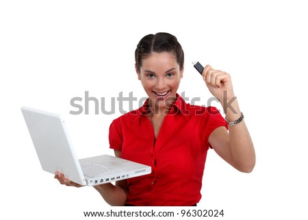 Happy woman with a USB key and laptop