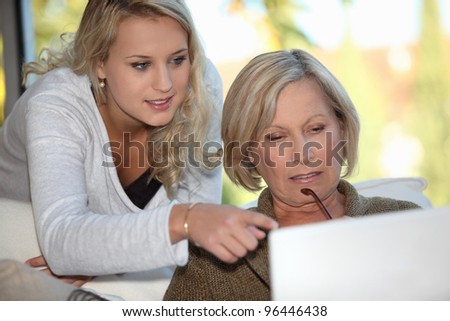 Granddaughter showing her grandmother how to use a computer