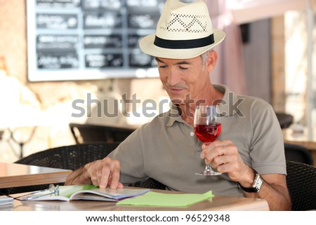 senior on vacation drinking fresh wine in a restaurant