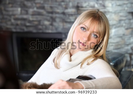 Woman sitting by fireplace