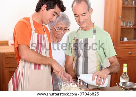 a 20 years old boy and 65 years old man and woman making cake together