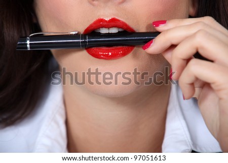 Woman with pen in mouth