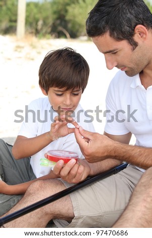 Father teaching his young son to fish