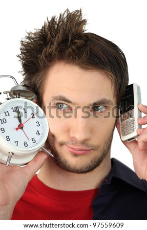 Man with alarm clock and mobile phone