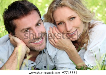 Happy couple lying on grass