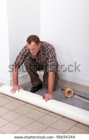 Man unrolling carpet roll