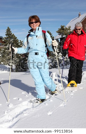 Middle-aged couple skiing to stay fit