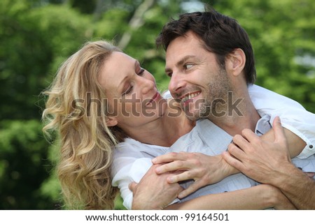 Blonde woman hugging man from behind