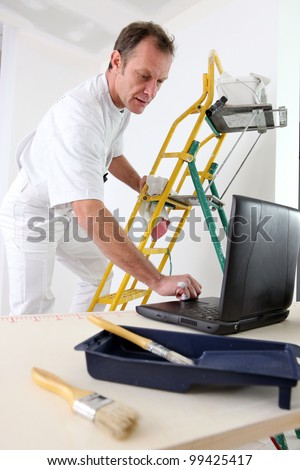 Painter taking quick break to reply to e-mail
