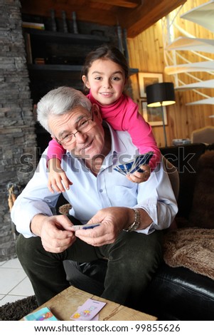 Little girl playing cards with grandpa