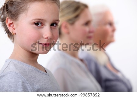 Little girl with mother and grandmother standing in line