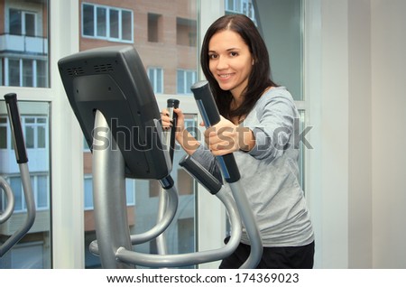 young woman doing exercise on a elliptical trainer