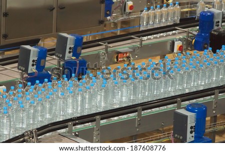 Plastic water bottles on conveyor and water bottling machine industry