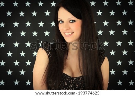 Portrait of young woman over dark background with white stars