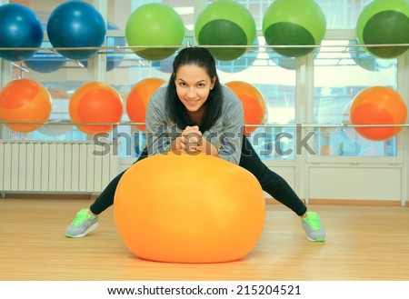 Young female with fit ball in sport center
