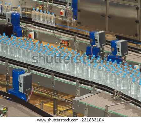 Plastic water bottles on conveyor and water bottling machine industry