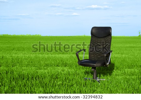 Office chair in a green grass with a deep blue sky
