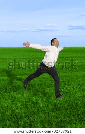 Running businessman in the meadow over clouds background