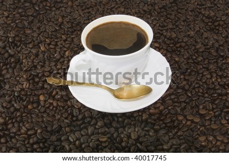 White coffee cup on brown roasted beans