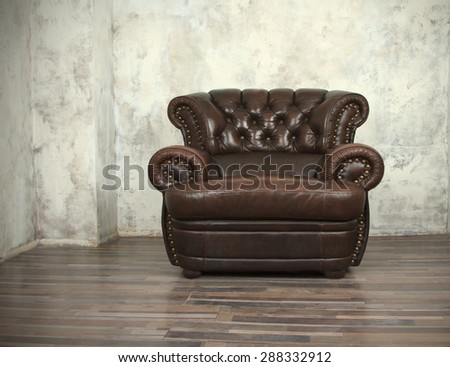 Old vintage brown leather chair in empty room