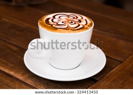 Cup of Cappuccino Coffee on a wooden table. Art Cappuccino.