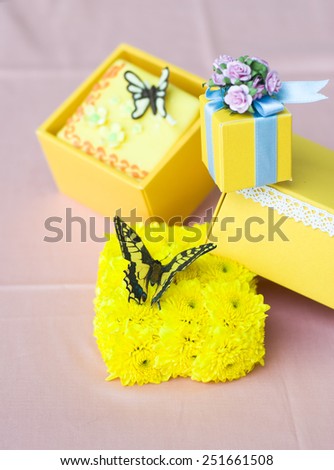 wedding theme with  butterfly and flower decoration in yellow gift boxes& blue ribbon    isolated on pink background