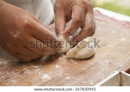 Man making polish  dumplings . Making of meat dumplings from stuffing and dough