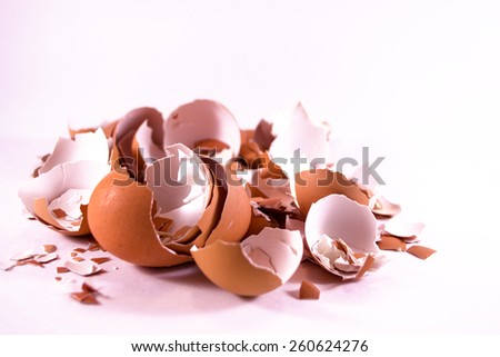 A pile of smashed crushed and broken eggshells on white background