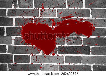 A single blood splat effect on a black and white brick wall