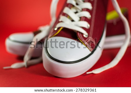 Red canvas trainer rubber sole detail on a cherry red background